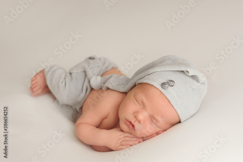 Cute infant Newborn baby in a  knitted hat on a blanket. Portrait of newborn baby. Face of sleeping small child
