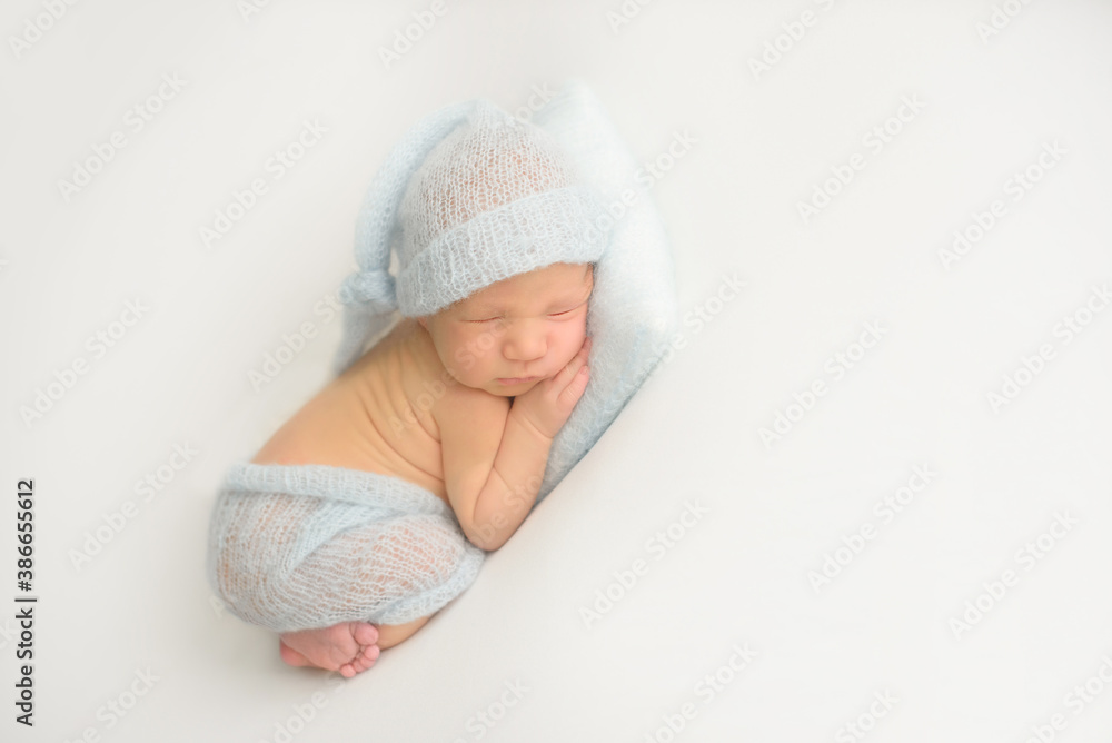 Sleeping newborn girl on a white blanket. Photoshoot for the newborn. 7 days from birth. A portrait of a beautiful, seven day old, newborn baby Sleeping newborn girl on a white blanket. Photoshoot for the newborn. 7 days from birth. A portrait of a beautiful, seven day old, newborn baby