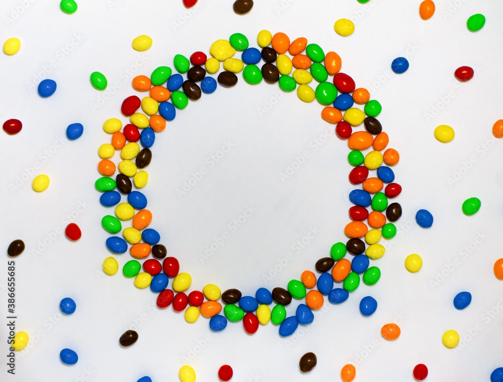 Top round frame of a colorful candy covered with chocolate on a white background with space for text Top round frame of a colorful candy covered with chocolate on a white background with space for text