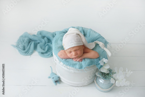 Cute infant Newborn baby in a  knitted hat on a blanket. Portrait of newborn baby. Face of sleeping small child
