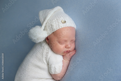 Cute llitlenewborn baby with blue blanket sleeping on soft blue coverlet 
