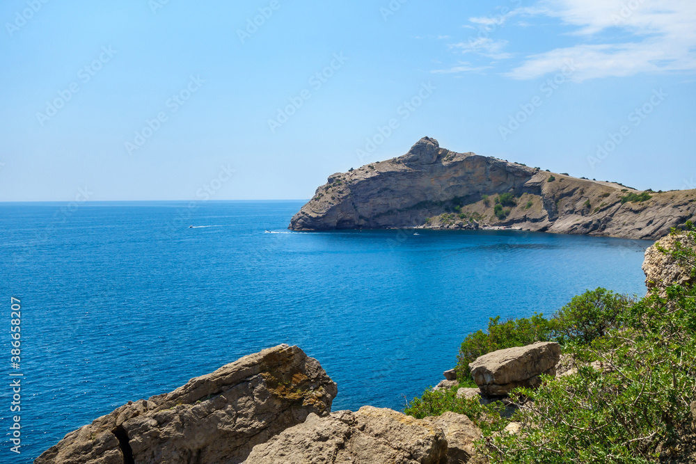 Panorama of cape Kapchik & Blue Bay. Silhouette of rocks reminds dolphin jumping out of water. Shot near town Novyi Svit, Crimea