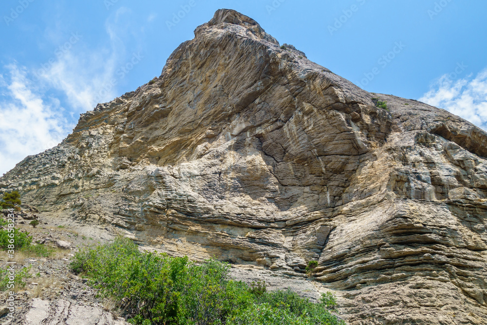 Mountain in shape of a fish tail rushes rapidly into the sky. Slopes show signs of wind and weather erosion. Shot in Novyi Svit, Crimea