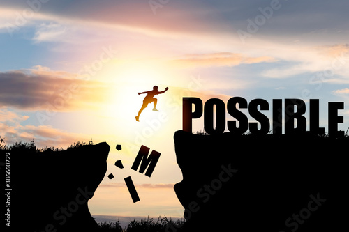Mindset concept ,Silhouette man jumping over impossible and possible  wording on cliff with cloud sky and sunlight. photo
