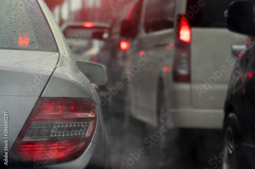 Abstract and blurred of rear side of car with drop of water on rainy time. with traffic jam.