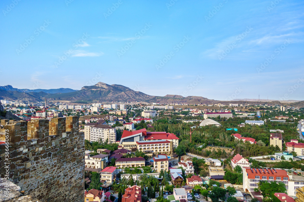 Panorama of resort town Sudak (Crimea) as it looks from top of Genoese fortress (part of it on left) - obrazy, fototapety, plakaty 