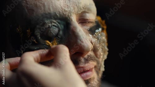 Obraz na plátne Special effects makeup artist with male model doing body paint and mask