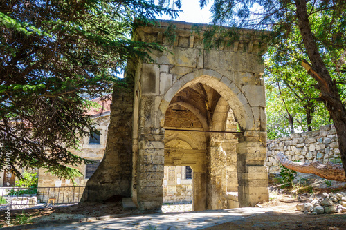 Remains of arch & part of outer wall of medieval Armenian monastery Surb Sarkis, Feodosia, Crimea. Main church is on background photo