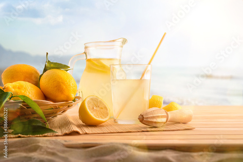 Breakfast with Jug and glass with lemonade on the beach