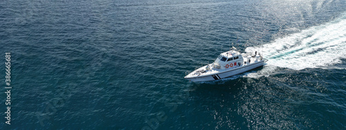 Obraz na plátně Aerial drone ultra wide photo of Hellenic Coast guard powerboat cruising in high