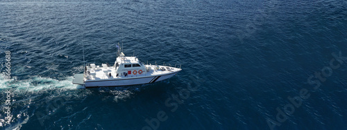 Aerial drone ultra wide photo of Hellenic Coast guard powerboat cruising in high speed near port of Piraeus, Attica, Greece © aerial-drone