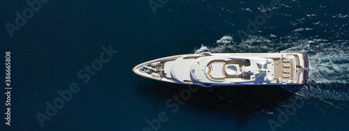 Aerial drone ultra wide photo of luxury yacht with wooden deck cruising in Aegean deep blue sea