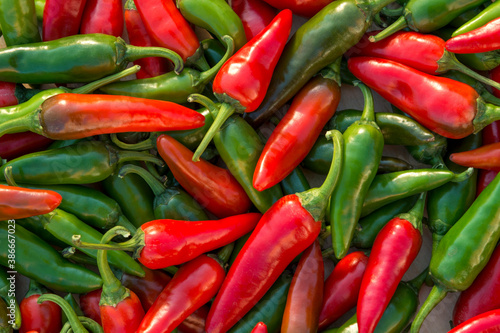 Photos Shot of  green and red hot chili peppers on the table