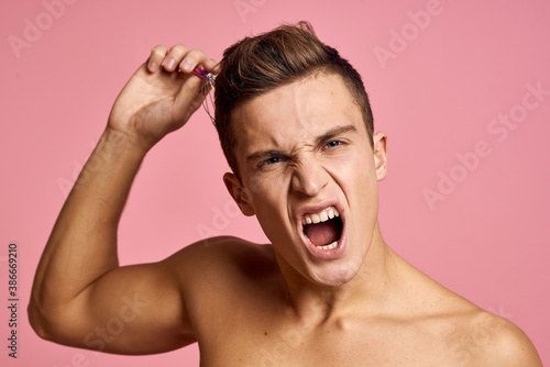 Nude man with head massager on pink background emotions model beautiful face