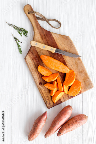 Sweet potato - sliced yams organic vegetables on cutting board, view from above