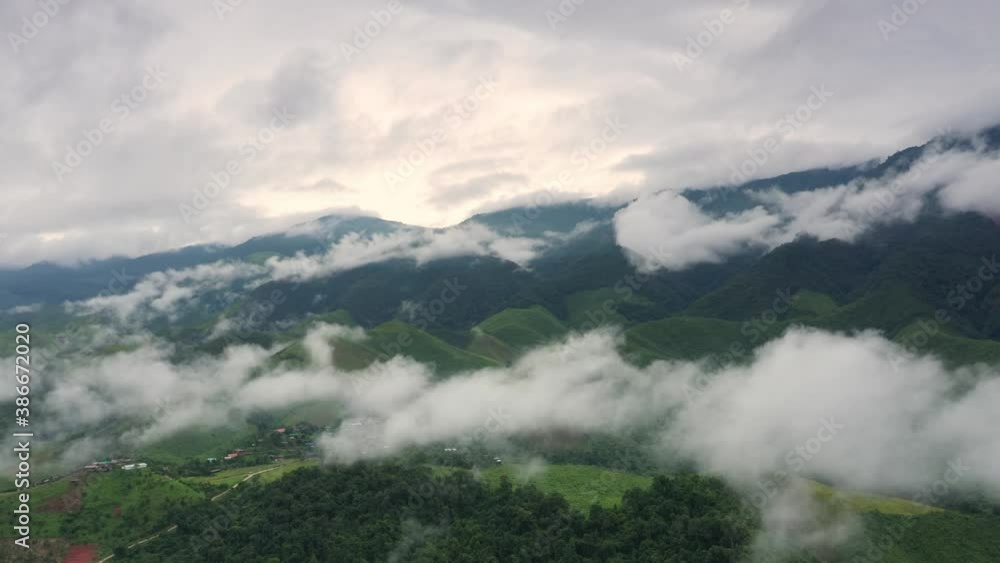 Aerial view over valley surrounded by mountains and covered with dense ground fog and mist High peaks wonderful morning sunrise natural Landscape. Sapan village, nan province, Thailand. 4k resolution Aerial view over valley surrounded by mountains and covered with dense ground fog and mist High peaks wonderful morning sunrise natural Landscape. Sapan village, nan province, Thailand. 4k resolution