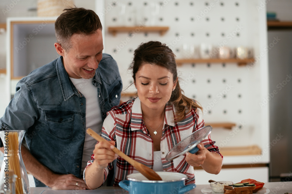 Husband and wife in kitchen. Young couple preparing delicious food at home. Husband and wife in kitchen. Young couple preparing delicious food at home.