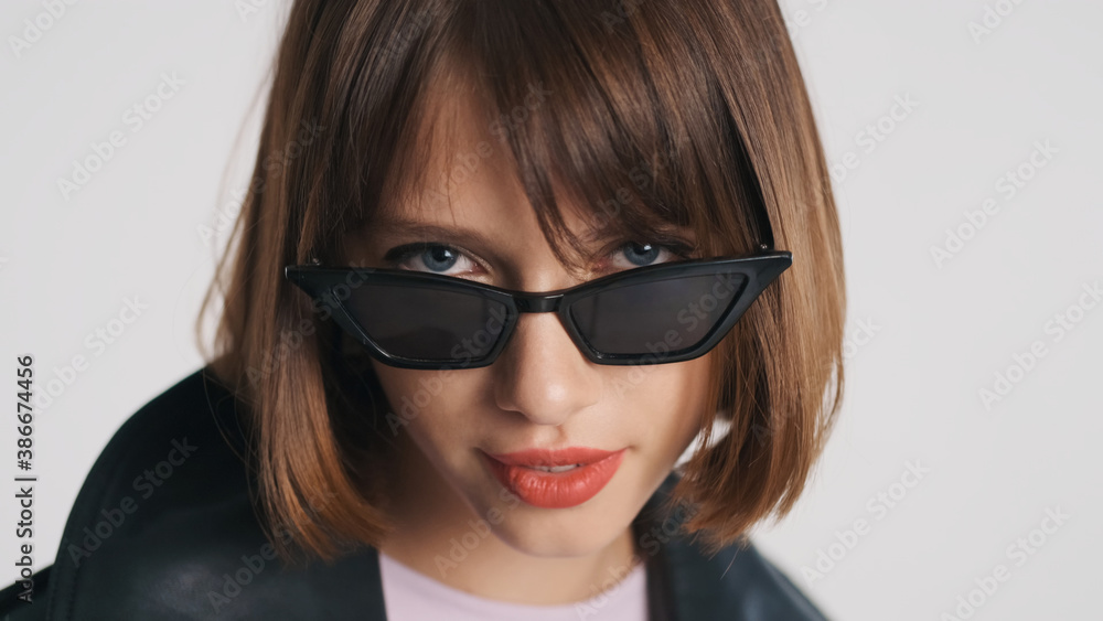 Portrait of blue eyed girl with bob hair and red lips wearing sunglasses isolated on white background Portrait of blue eyed girl with bob hair and red lips wearing sunglasses isolated on white background
