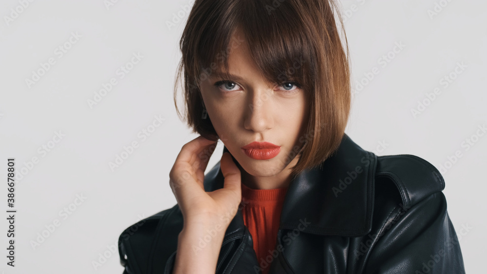 Fashion girl with bob hair and red lips looking serious over white background. Professional model posing in studio Fashion girl with bob hair and red lips looking serious over white background. Professional model posing in studio