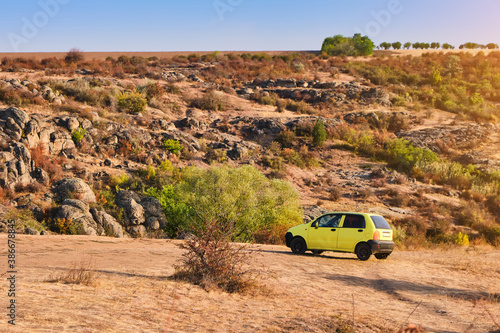 Yellow car on the background of the hills of the Canyon