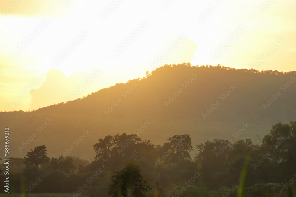Blurred Orange sky background picture with mountains shining in the morning in a rural village in the middle of the valley