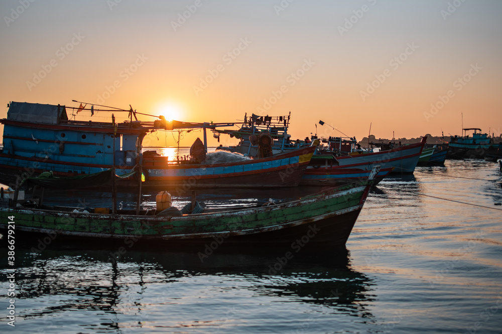 Sunset over colorful traditional wooden fishing boats, Cgaun Thar, Irrawaddy, Myanmar