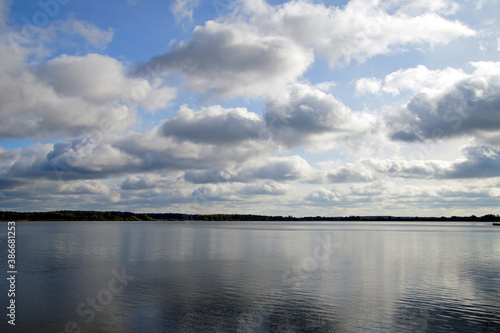 Autumn landscape. Beautiful white clouds in the blue sky above the lake. October. Day © Anatoliy