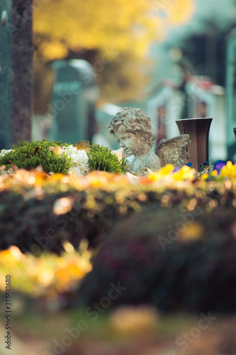 Remembrance concept: White angel on a grave, flowers photo