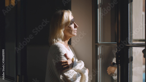 Side view of pensive mature businesswoman looking out of window indoors