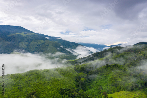 Aerial view over valley surrounded by mountains and covered with dense ground fog and mist High peaks wonderful morning sunrise natural Landscape. Sapan village, nan province, Thailand.