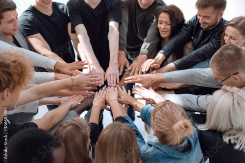 group of diverse people joining their hands in a circle. © ASDF