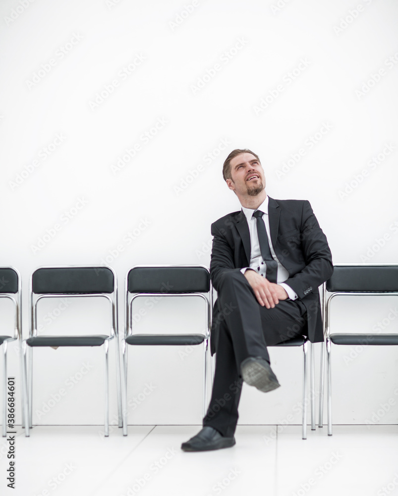 thoughtful businessman sitting in the office hallway thoughtful businessman sitting in the office hallway