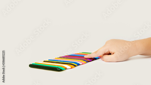 Children hand holding wax crayons on white background.