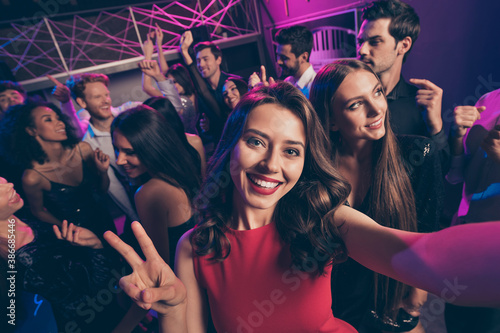 Self-portrait of nice attractive cheerful crowd dancing having fun enjoying event relax chill showing v-sign in dark night music club indoors