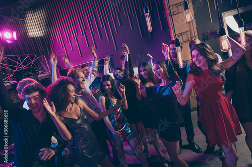 Nice attractive cheerful crowd dancing having fun celebratory festal corporate event newyear in dark night music club indoors