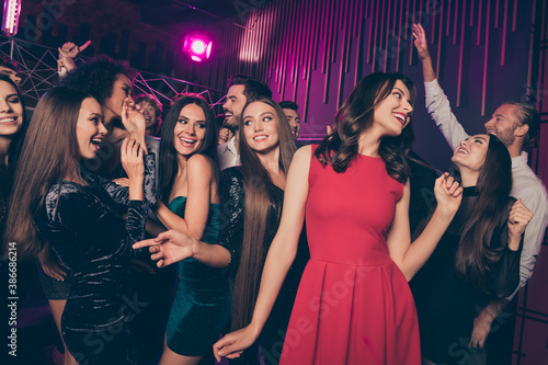 Photo of friends company celebrating new year corporate party in night club joking laughing dancing together in luxury stylish clothes