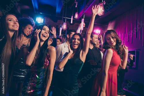 Photo portrait of happy young people dancing together cheering raising hands up cheering dj