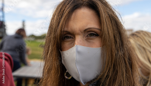 Middle aged woman wearing a protective cloth face mask to prevent the spread of covid-19 coronavirus during the pandemic