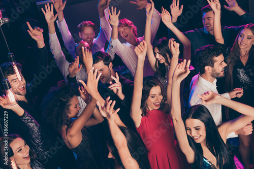 Attractive elegant trendy cheerful crowd dancing rising hands up chill relax visiting concert dark night music club indoors