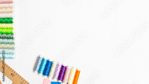 many multi-colored threads laid out in a row on the right on a white background with a copy space