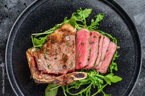 Rare sliced grilled club beef meat steak. Black background. Top view