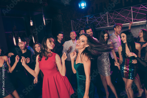 Attractive chic glad smart elegant cheerful friends dancing having fun disco event in modern new dark night club indoors