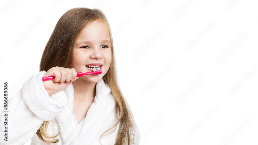 little happy beautiful preschooler girl brushes her teeth with a pink toothbrush smiling looking to the side on a white background with copy space. little happy beautiful preschooler girl brushes her teeth with a pink toothbrush smiling looking to the side on a white background with copy space.