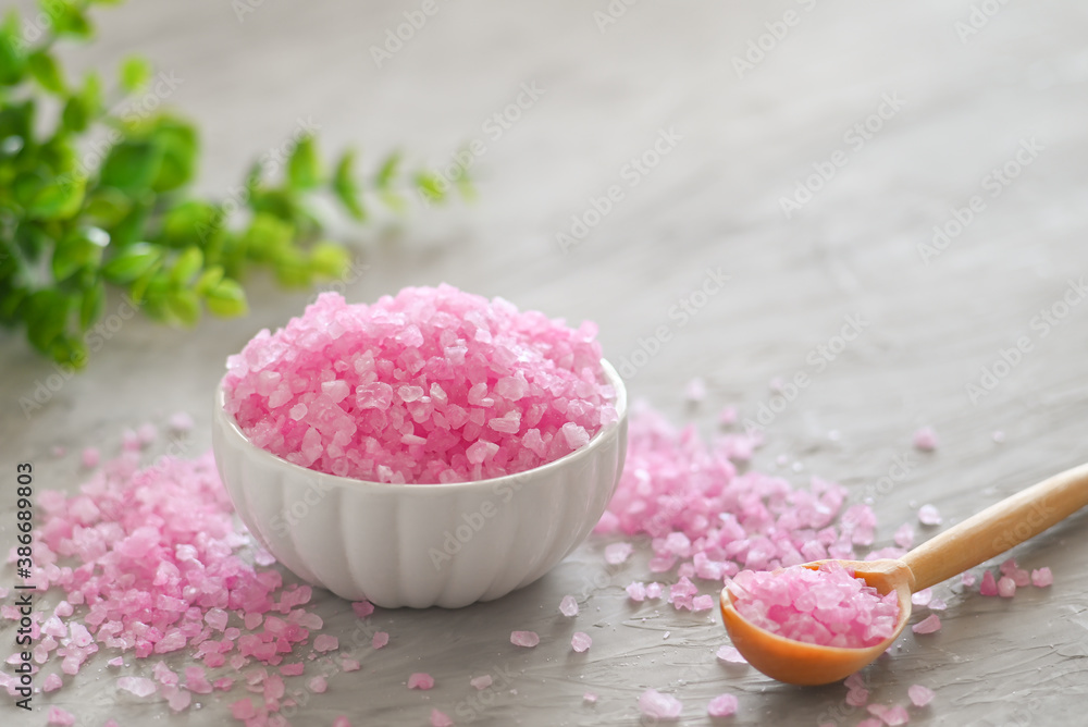 Herbal cosmetics. Pink close-up of bath salt in the glass bowl with aroma candles with copy space Herbal cosmetics. Pink close-up of bath salt in the glass bowl with aroma candles with copy space