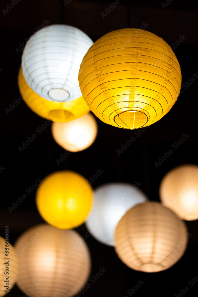 Fototapeta premium Group of colorful sphere paper lighting lamp on black background, background and texture photo. Selective focus at some piece of the lamp surface.