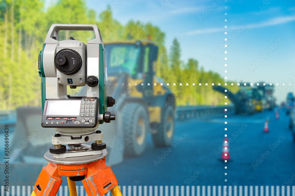 Surveyor job. Survey equipment on the construction site. Geodetic works during construction of the road. Theodolite on the background of a highway under construction. Measuring equipment. Surveyor job. Survey equipment on the construction site. Geodetic works during construction of the road. Theodolite on the background of a highway under construction. Measuring equipment.