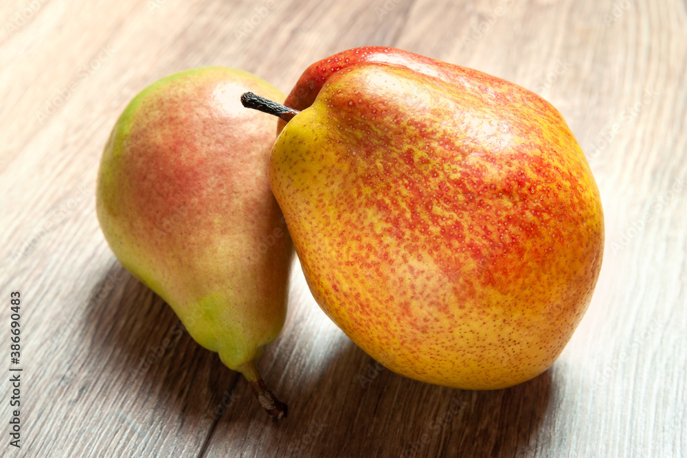 Close-up of two pears. Two fresh ripe organic pears on a wooden background. Vegetarian, vegan healthy food. Diet organic product. Selective soft focus.