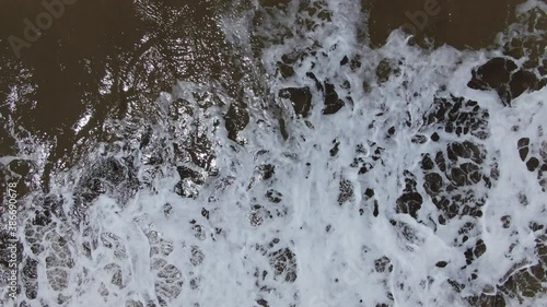 Video con vista cenital a baja altura, de las olas de la costa del océano. photo