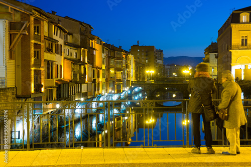 Scenic view of illuminated houses along Agout river in French city of Castres in twilight photo