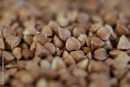 Buckwheat in a bowl, and scattered on the table, close-up.
